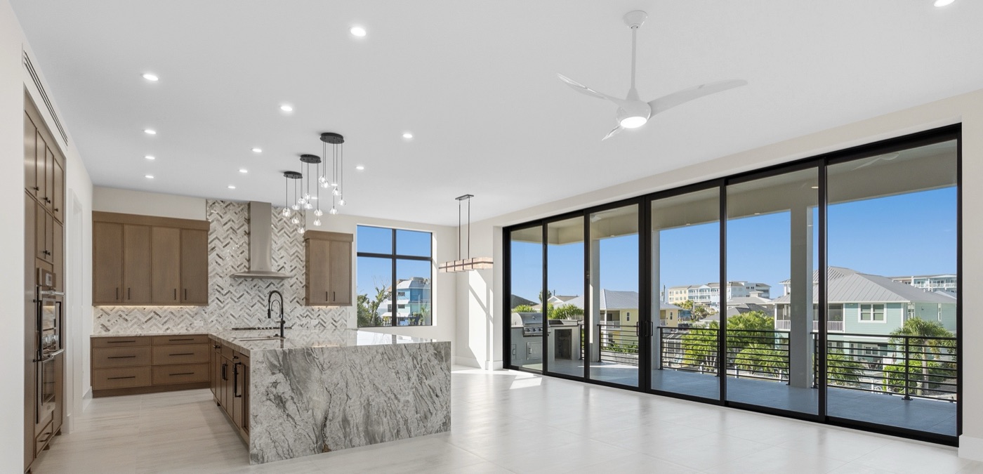 Open-concept great room and kitchen with lanai sliders